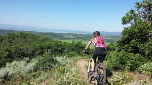 Kate biking in a beautiful trail